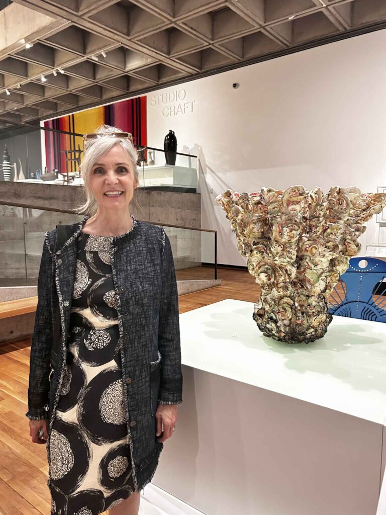 Susan Collett, standing beside her artwork Bloom